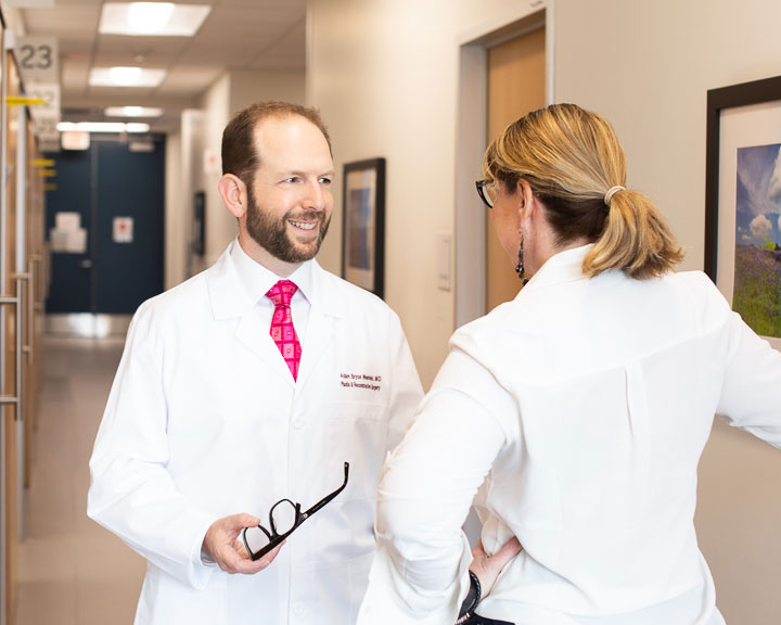 Alt description: Dr. Weinfeld and staff talking in the hallway 